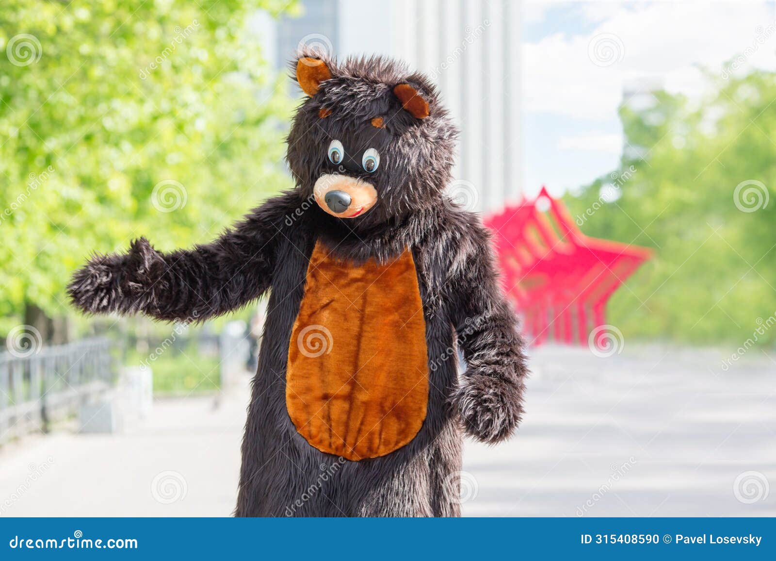 actor dressed as bear walks avenue of park on
