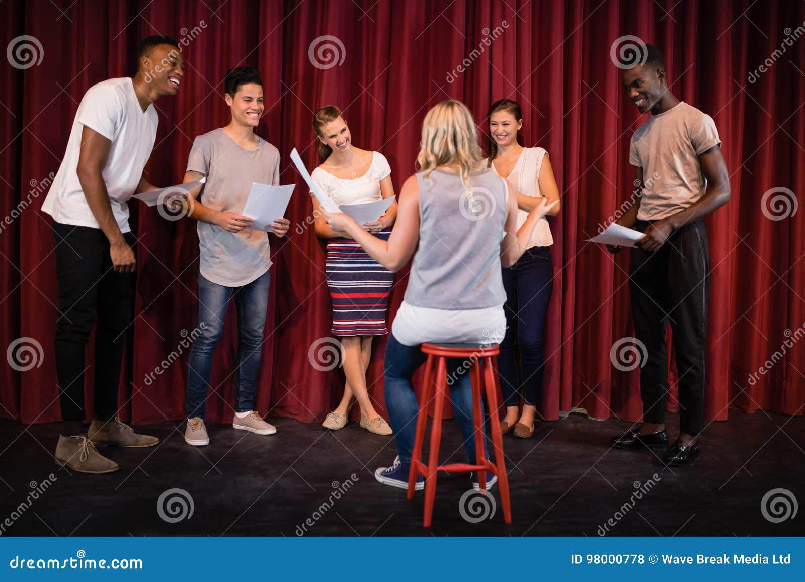 actors reading their scripts on stage