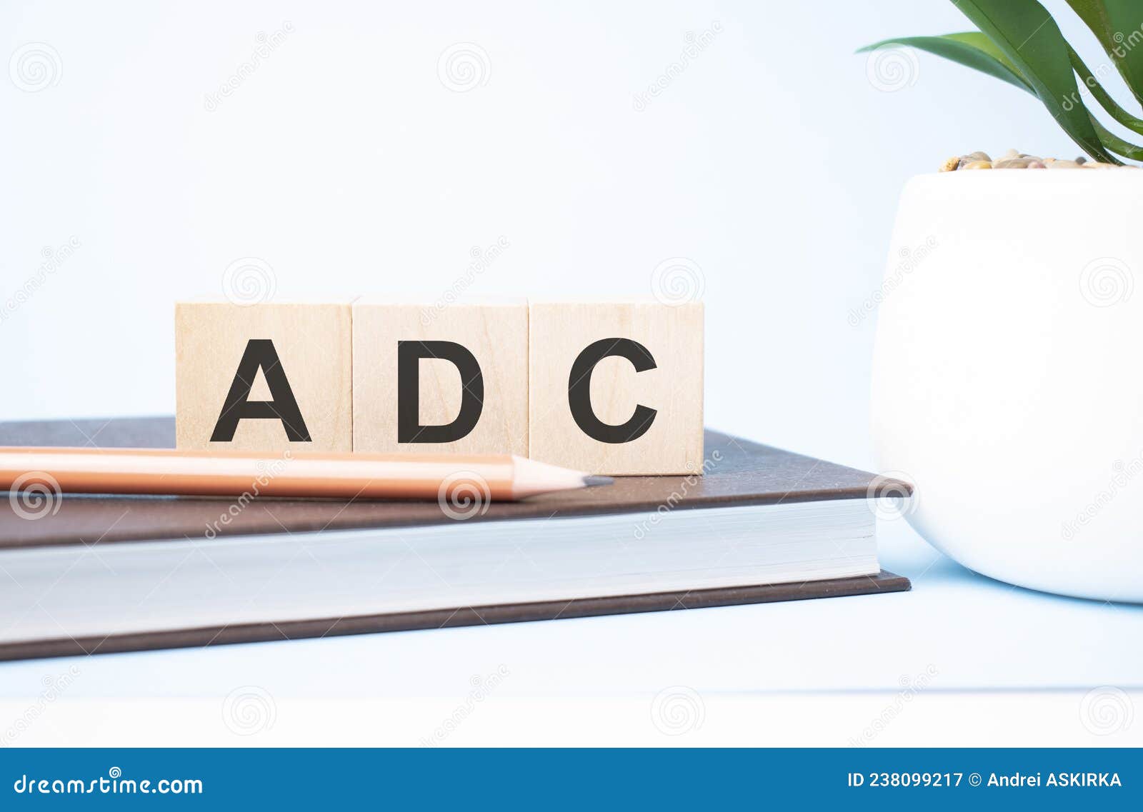 adc acronym on building blocks supported by two different size pencils. copy space