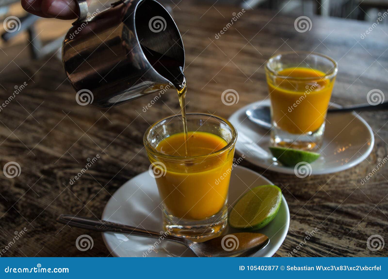 Adding Honey To Two Healthy Jamu Shots In Close up Stock 