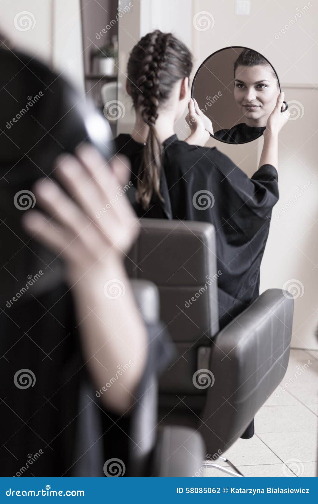 Woman admiring new hairstyle in the mirror