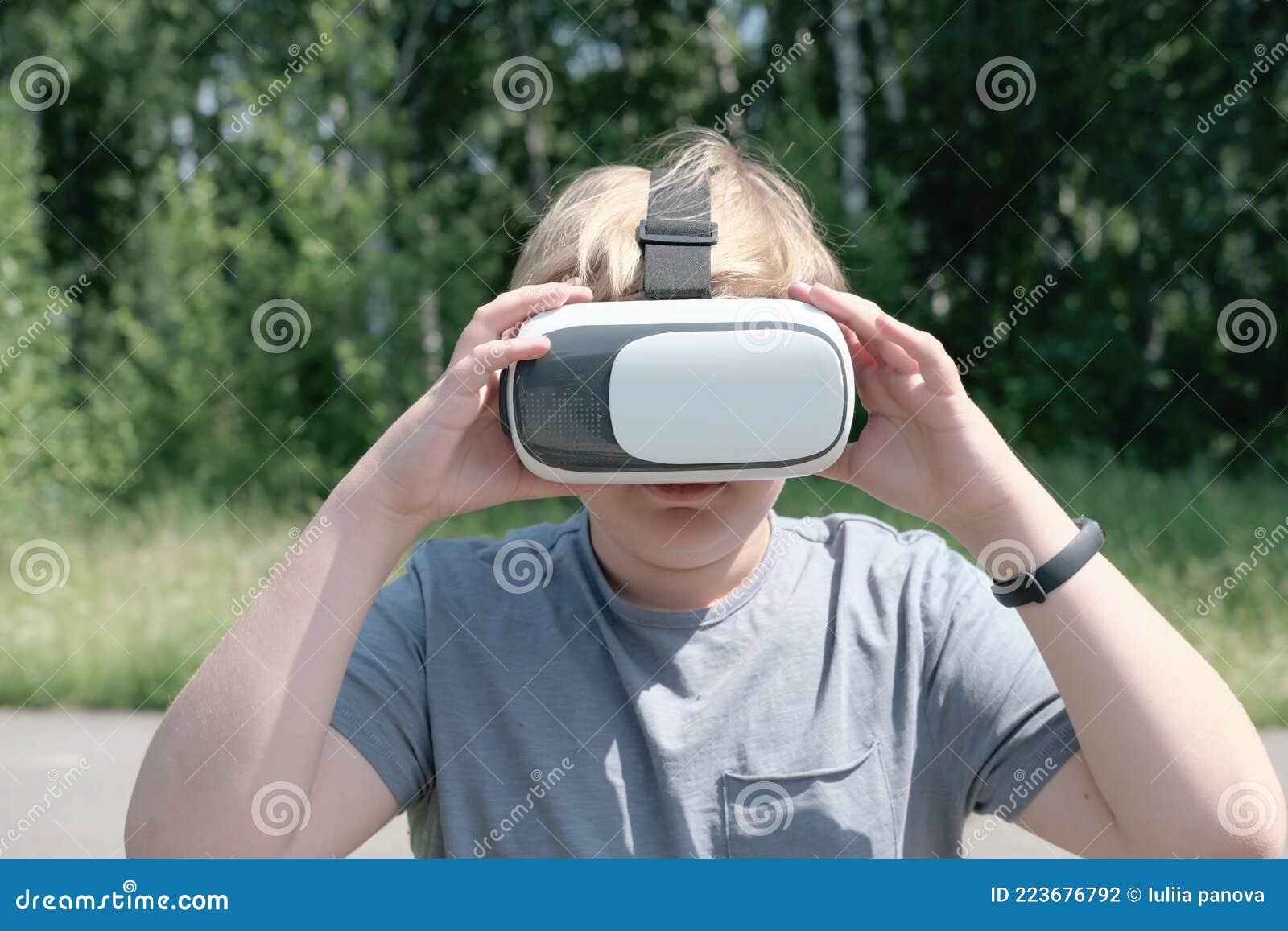 Adolescent Blond En Utilisant Le Casque Vr Pour Jouer à L'extérieur.  Adolescent Touchant Un Gadget De Réalité Virtuelle Photo stock - Image du  adolescents, passionnant: 223676792