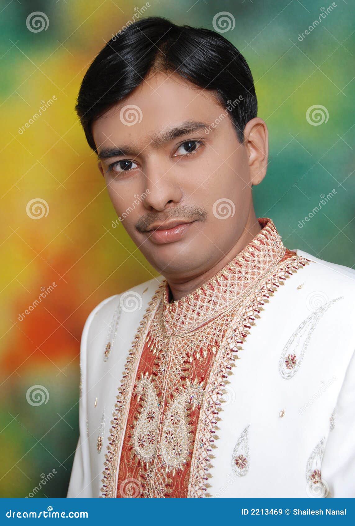 Un adolescente indiano bello in un vestito tradizionale di unione.