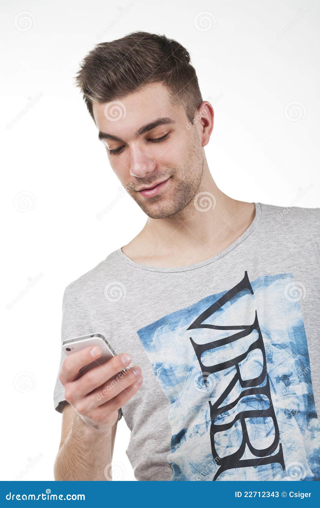 Adolescente joven con el teléfono elegante blanco. El hombre joven hermoso en un desgaste de moda toma un teléfono elegante blanco.