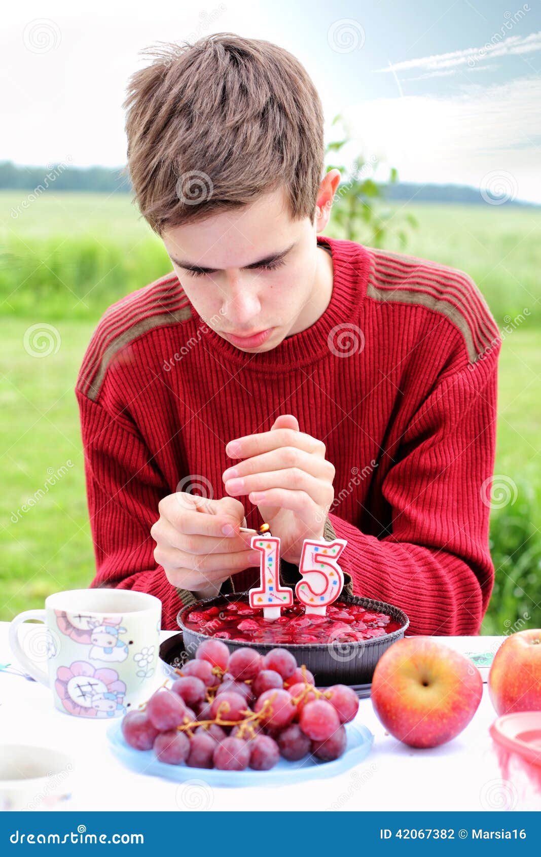 Adolescente sul suo compleanno. Adolescente che accende le candele sulla torta di compleanno con il numero 15 su