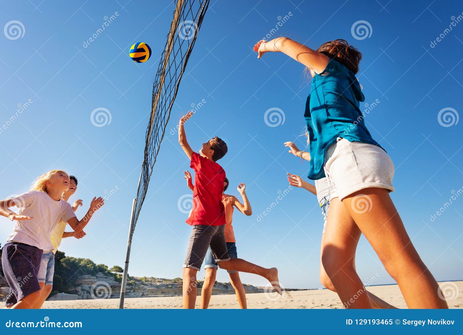 Festa na praia. atividades de férias de verão. jovens jogando vôlei na  costa arenosa e ouvindo música. esporte tropical, verão. jogo de bola.
