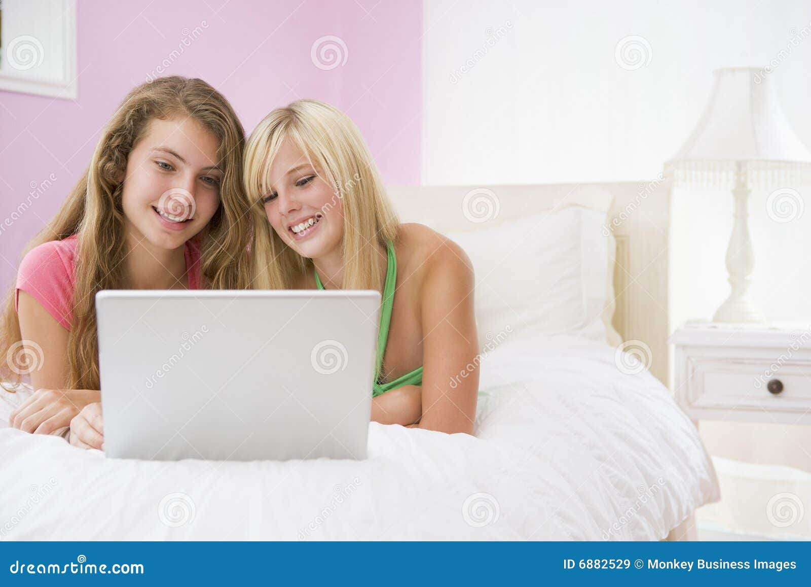 Молодые расслабляются. Девушка подросток лежит. Teenage girl lying on Bed using a Laptop. Teenage lying.