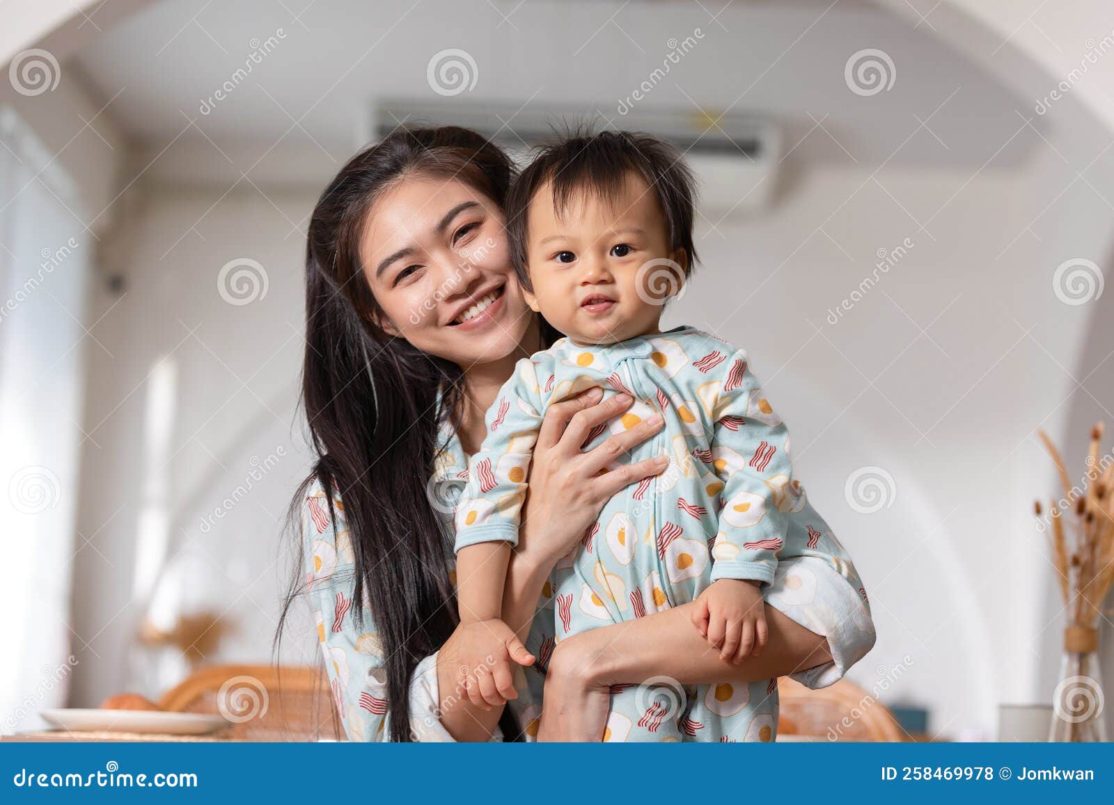Adorable Asian Baby Smiling with Mom Hugging with Love at Warmth Place