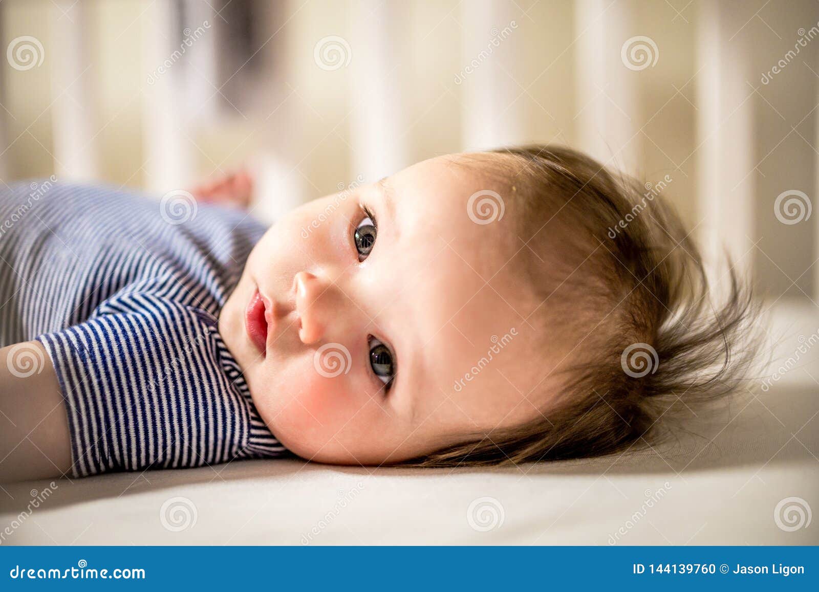 adorable baby girl lays in crib