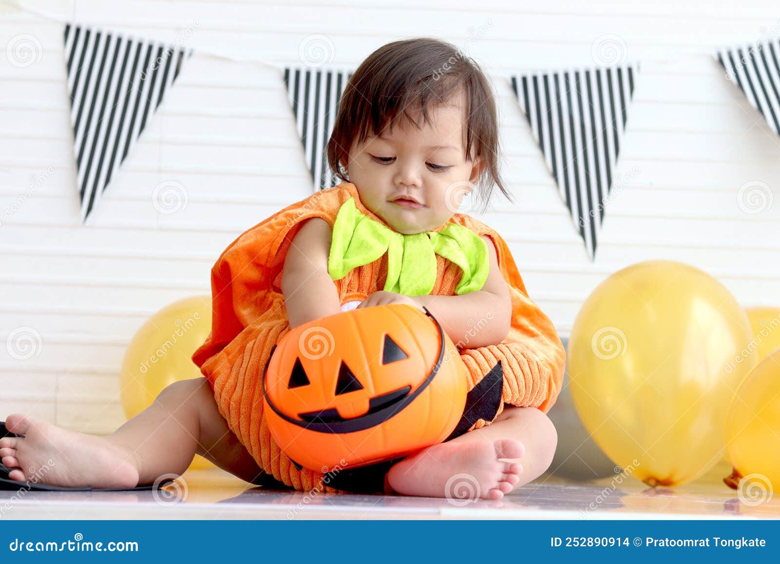 Bebé recién nacido se sienta en un disfraz de calabaza en un disfraz de  halloween de fondo negro