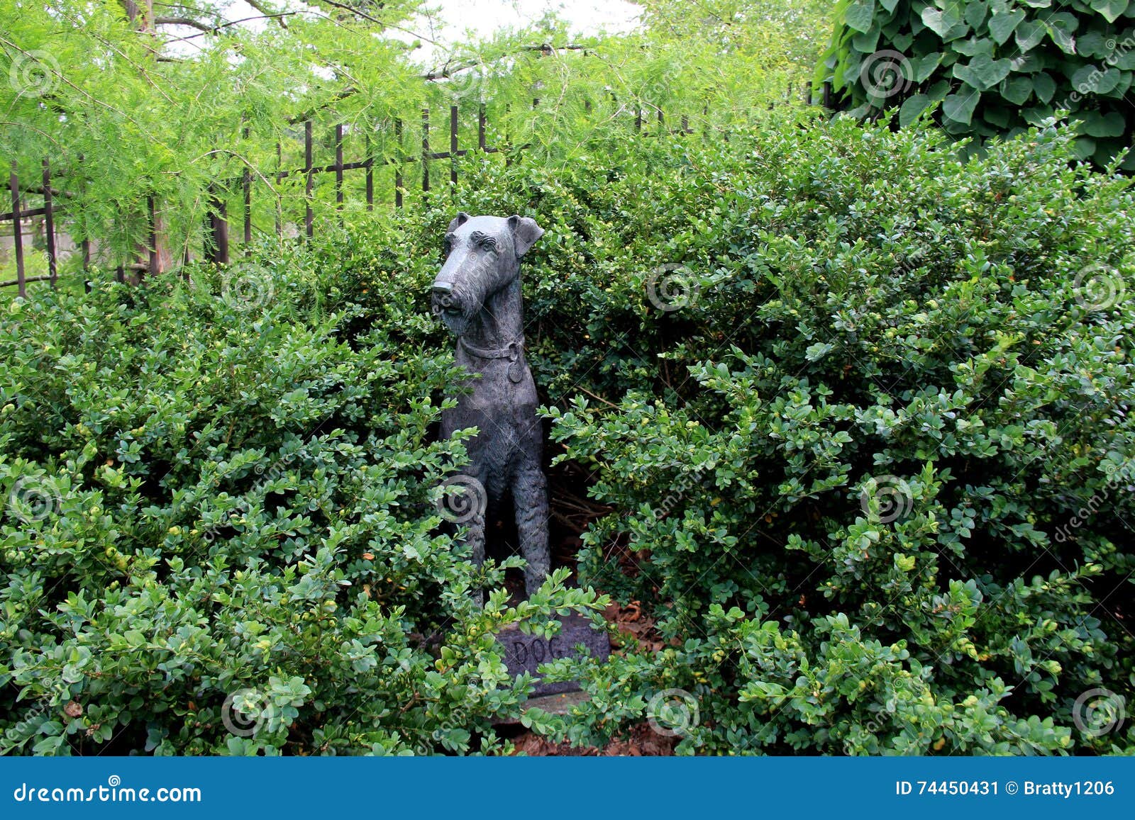 Adorable Detail Of Carved Dog Sculpture Tucked Into Garden