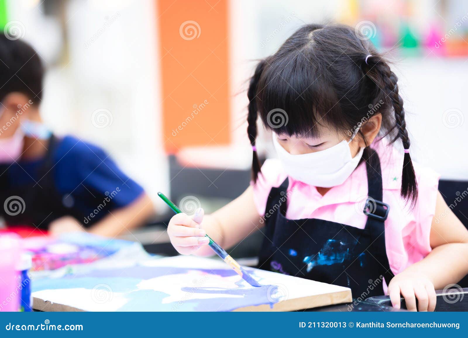 adorable girl studied art and paint on canvas in handicraft class.