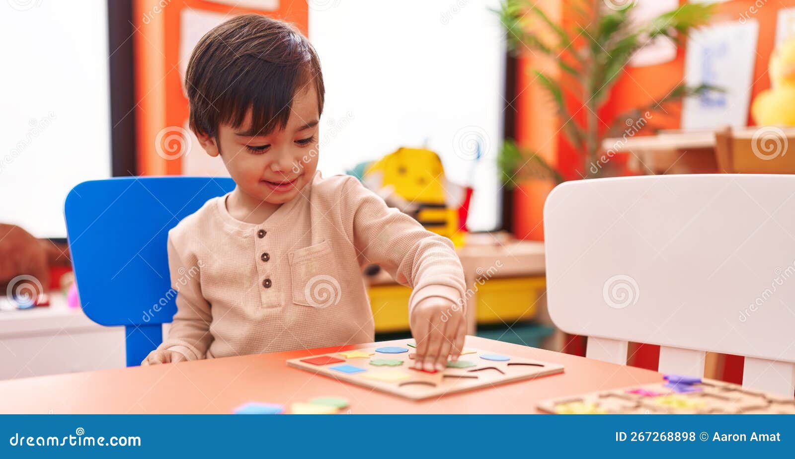 Adorable Hispanic Boy Playing with Maths Puzzle Game Sitting on Table