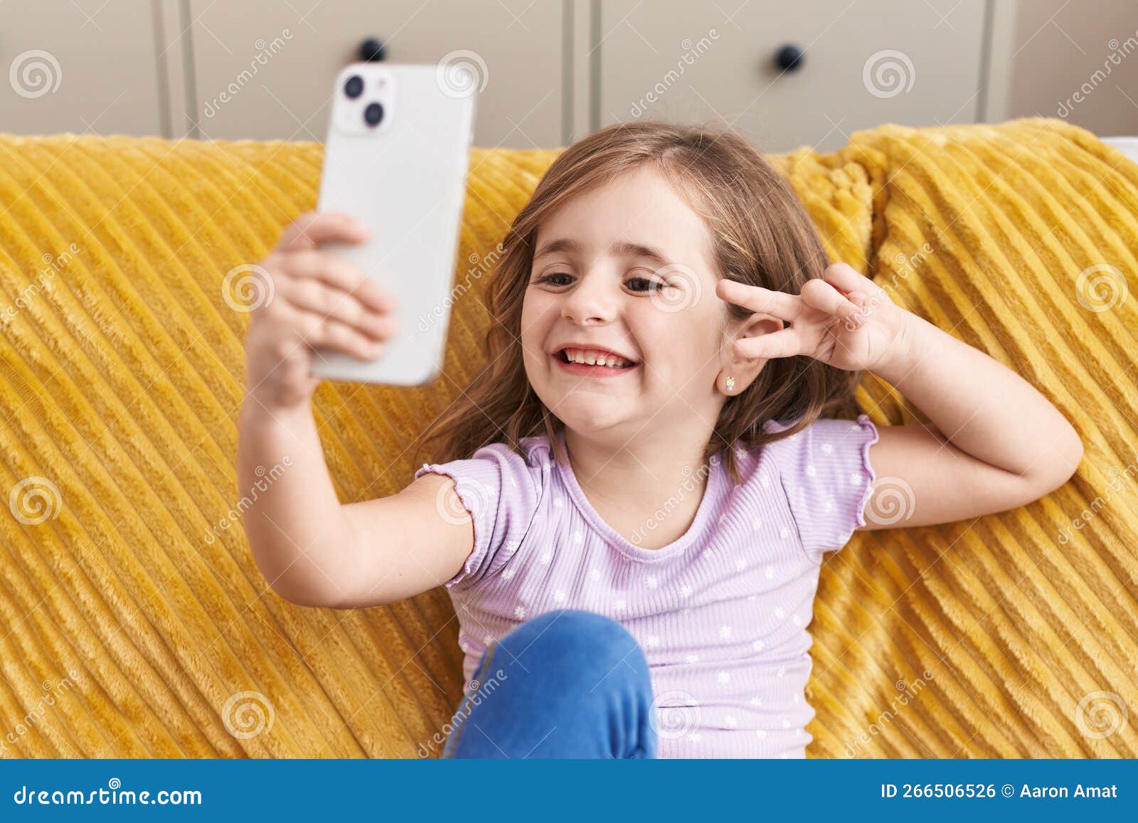 Adorable Hispanic Girl Make Selfie by Smartphone Sitting on Sofa at ...