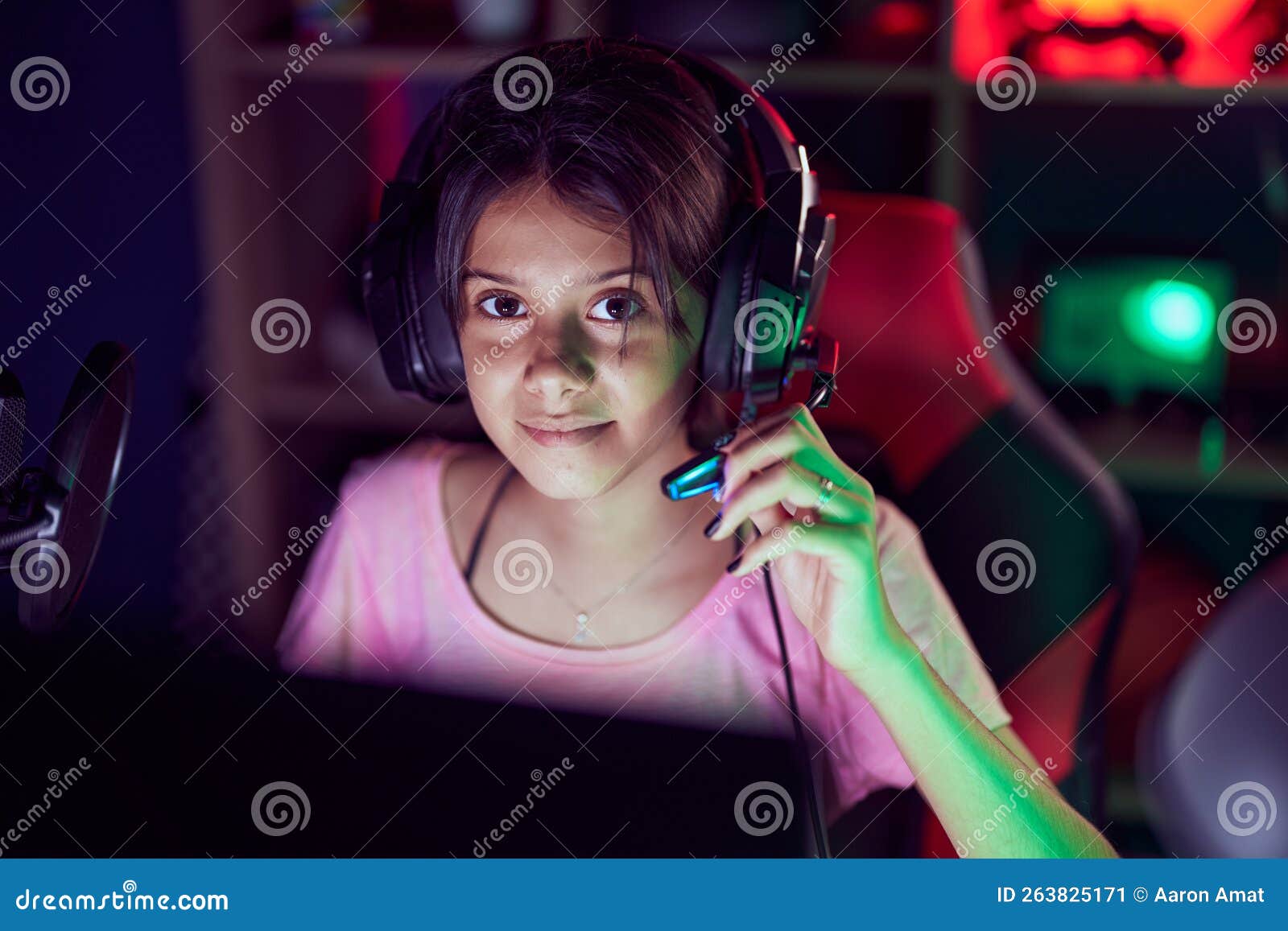 Adorable Hispanic Girl Streamer Playing Video Game Using Computer at