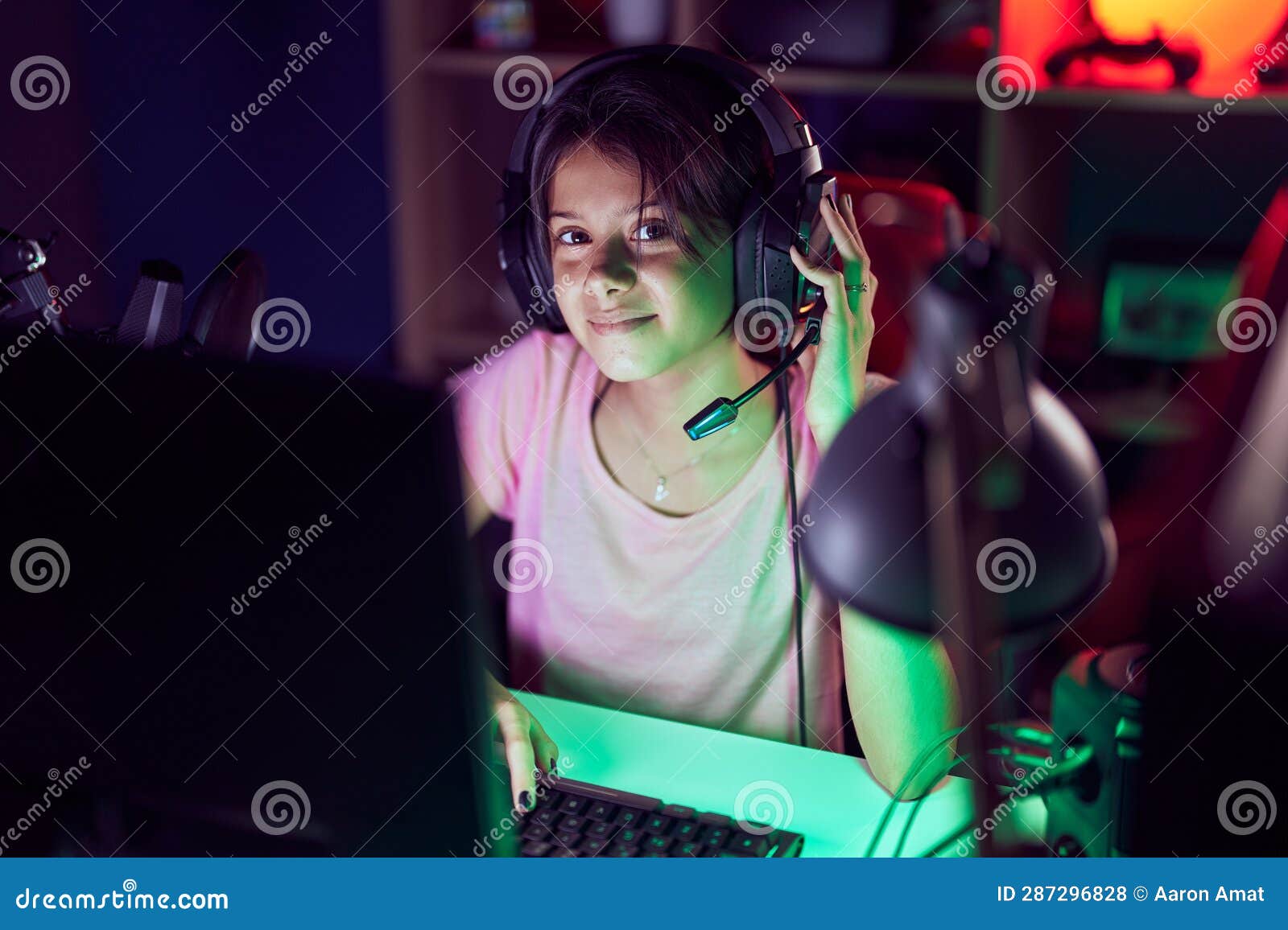 Adorable Hispanic Girl Streamer Playing Video Game Using Computer at