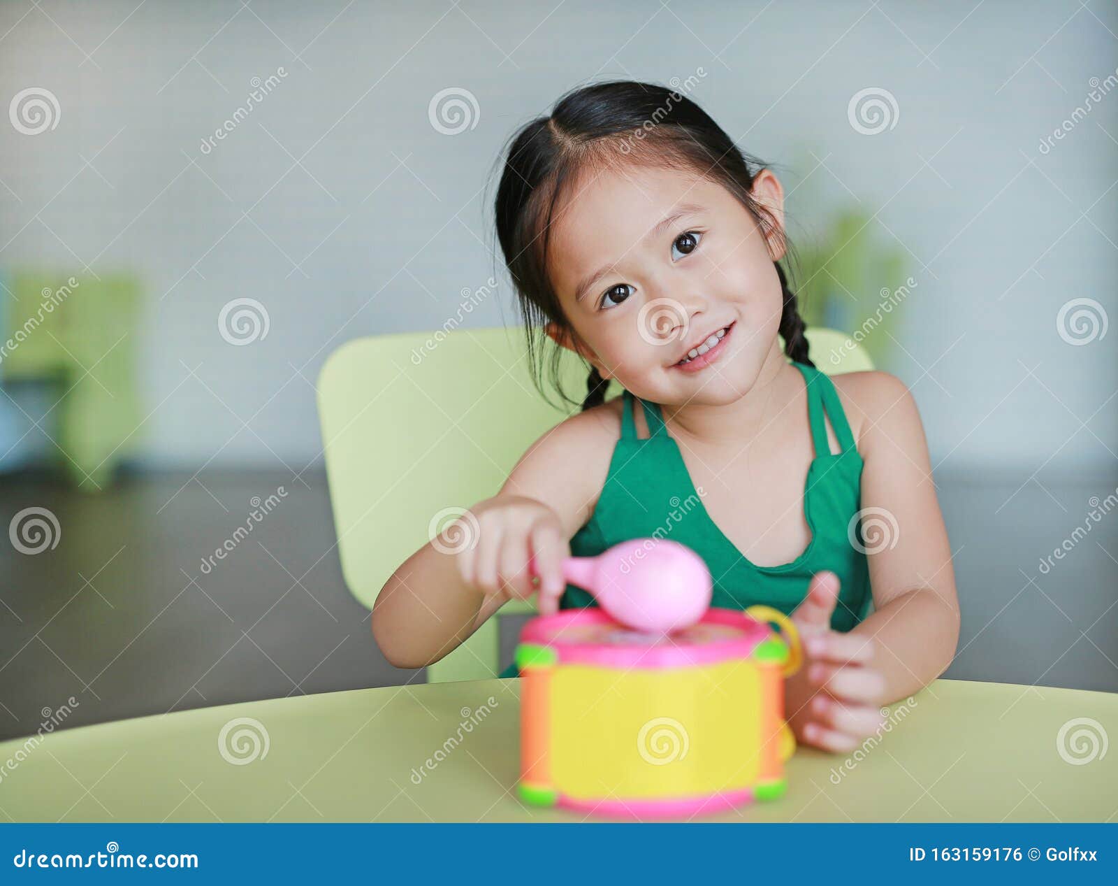 Adorable Little Asian Child Girl Play Hitting Toy Drum In Childre