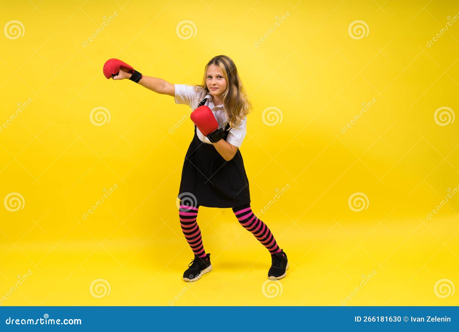Adorable Little Girl Boxer Practicing Punches in Studio Stock Photo