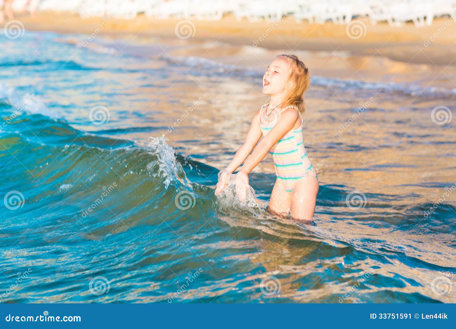 adorable little girl playing in the sea on a beach