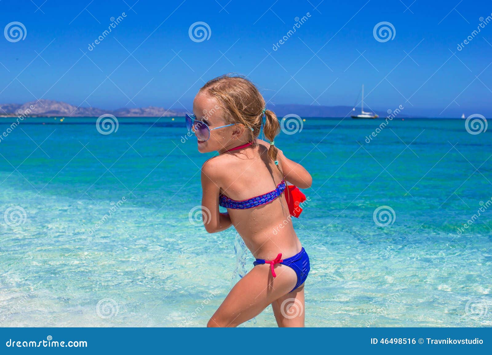 adorable little girl playing with toy on beach