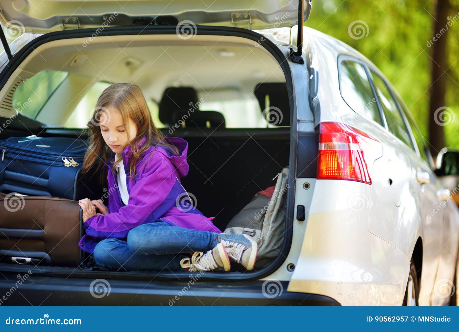 adorable little girl ready to go on vacations with her parents. kid relaxing in a car before a road trip.