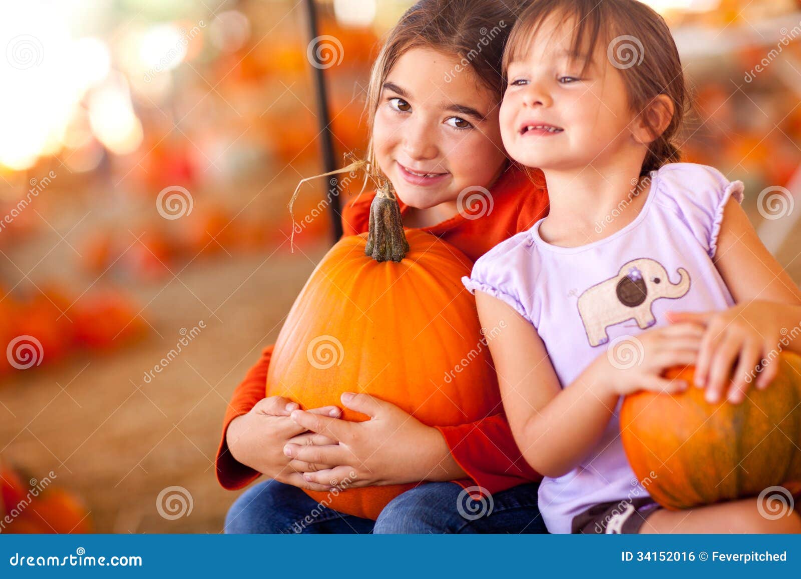 Adorable Little Girls Holding Their Pumpkins At A Pumpkin Patch. Cute Little Girls Holding Their Pumpkins At A Pumpkin Patch One Fall Day.