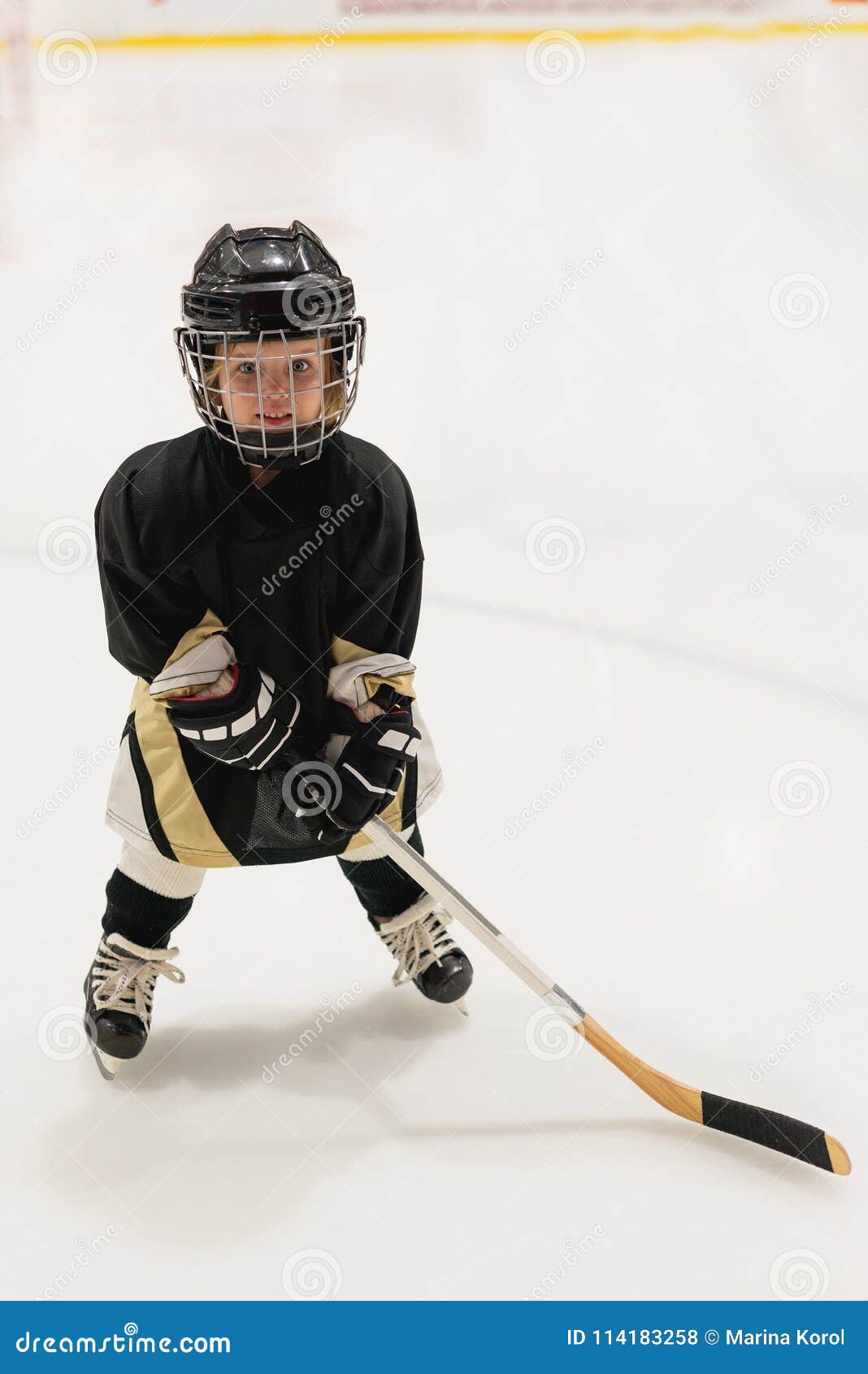 Isolated cute little kid hockey player in full hockey equipment