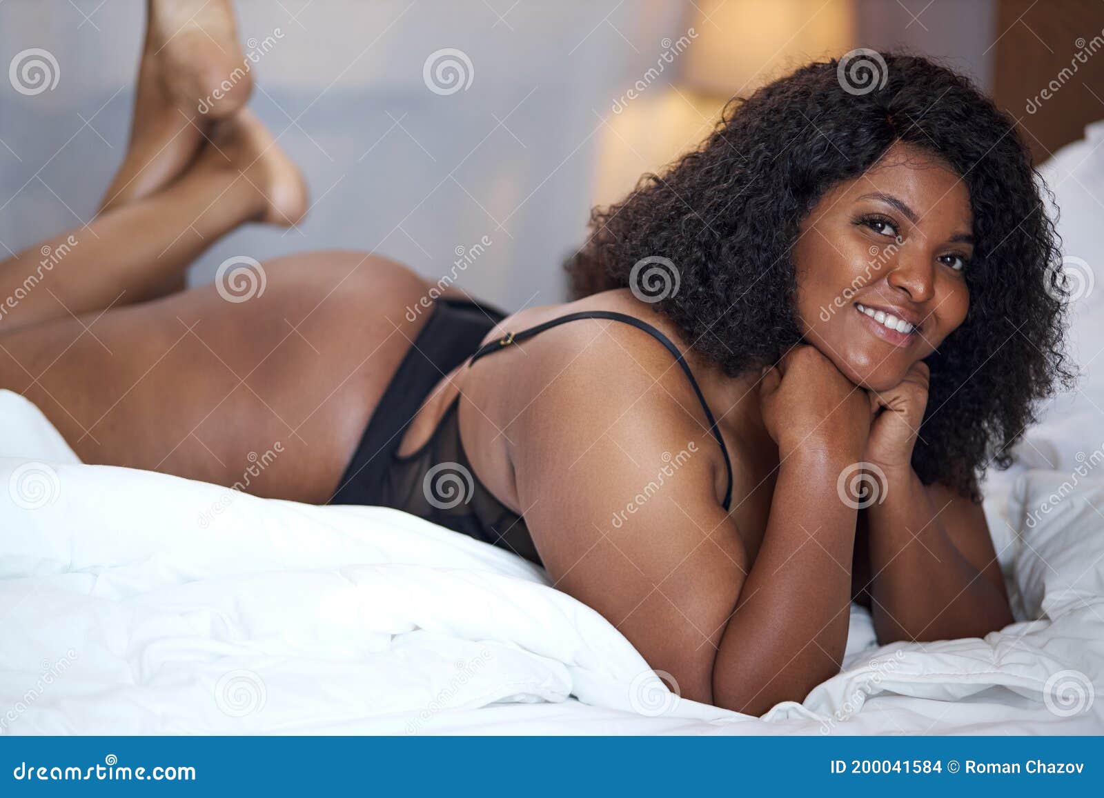 Adorable Mujer Africana Sexy Acostada En La Cama En Casa Foto de archivo