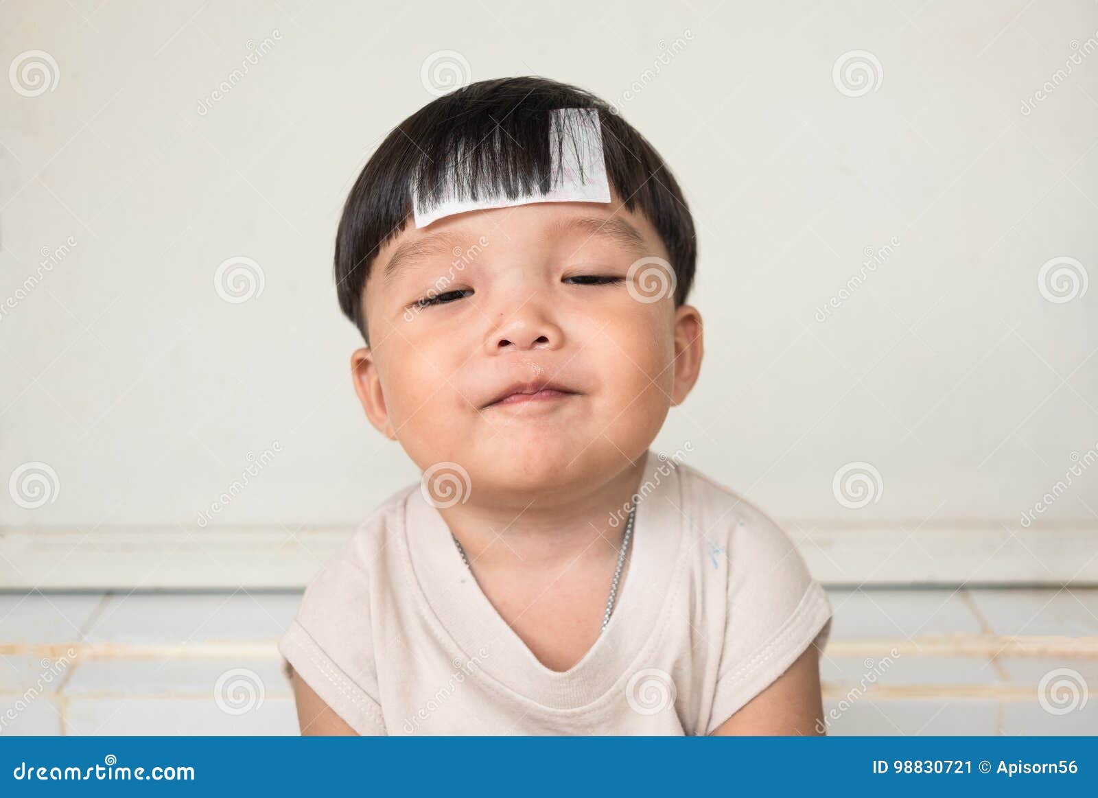 adorable plump boy smilingly with chubby cheeked and close eyes. front view of kid with illness