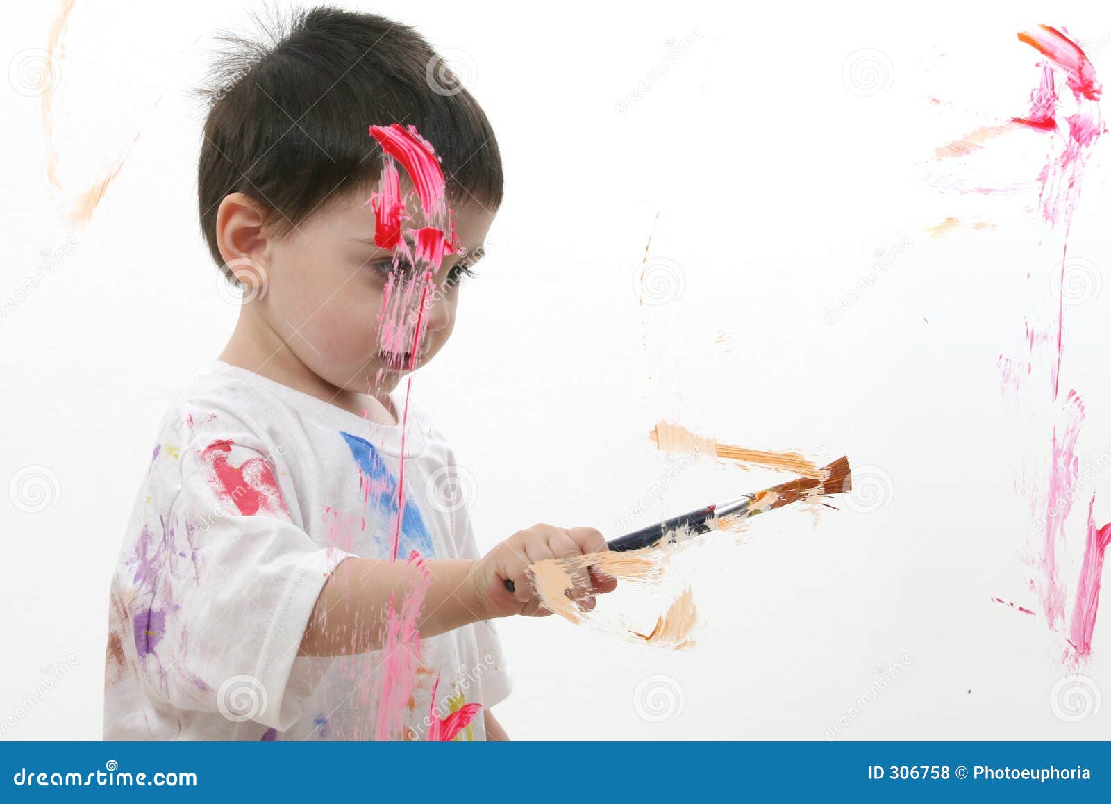 adorable toddler boy painting on glass