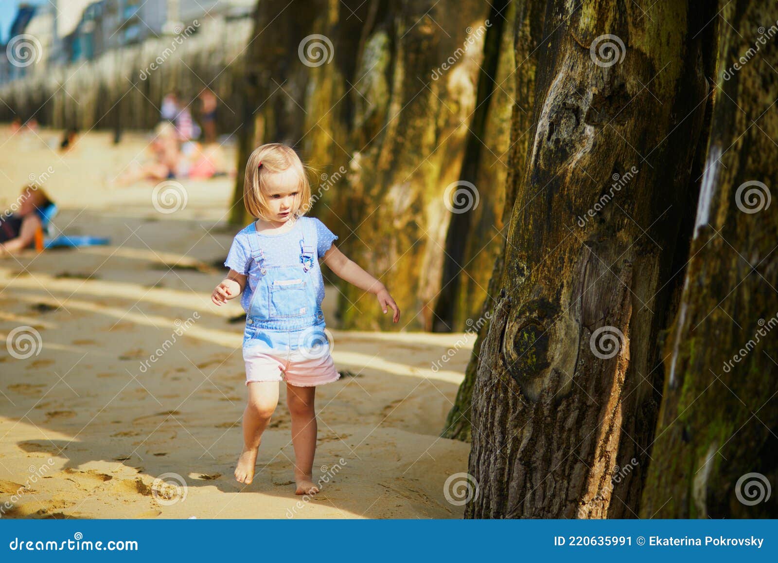 adorable toddler girl having fun on sillon beach in saint-malo, brittany, france