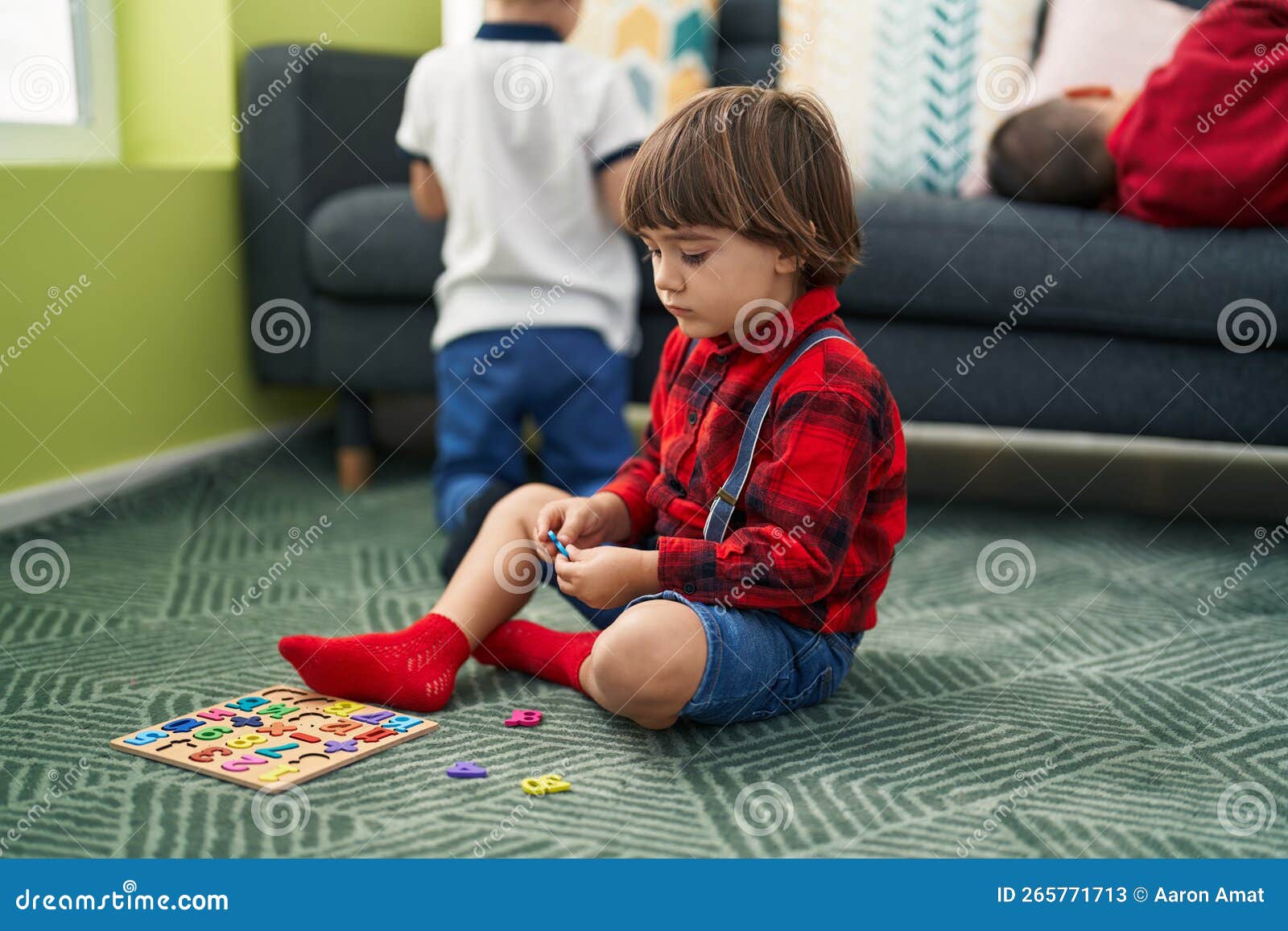 Adorable Toddler Playing with Maths Game Sitting on Floor at Home Stock