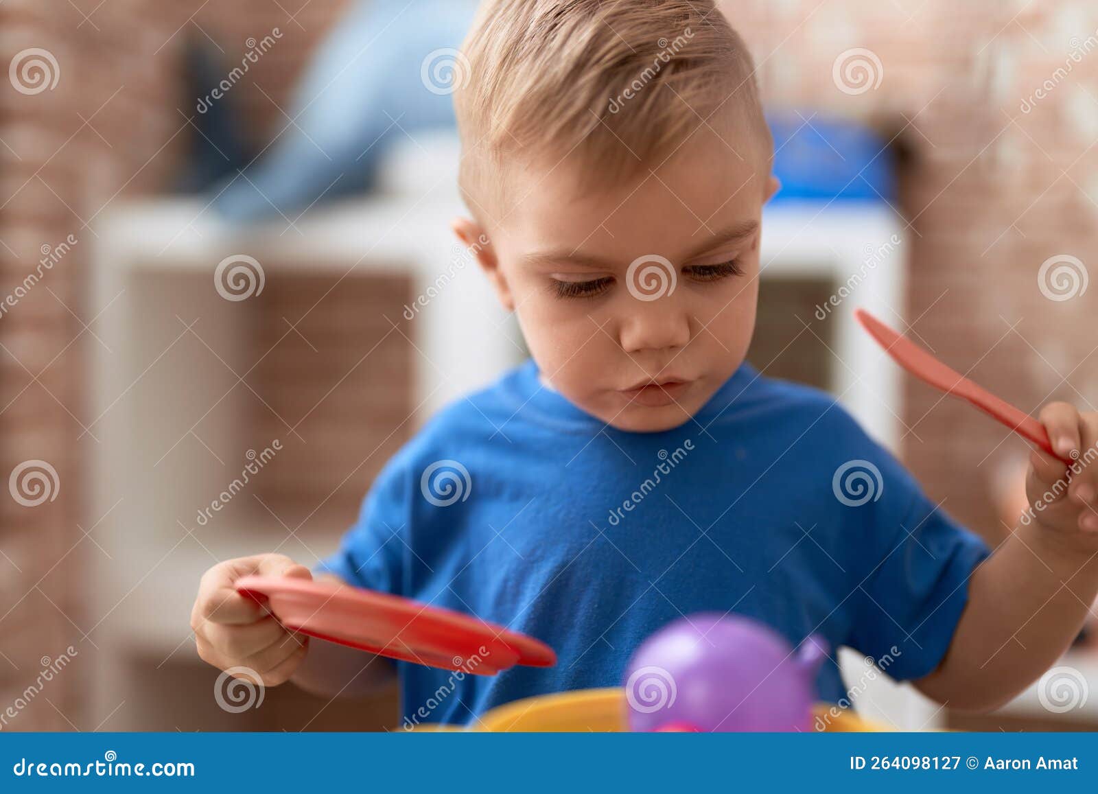 Adorable Toddler Playing with Play Kitchen Standing at Kindergarten