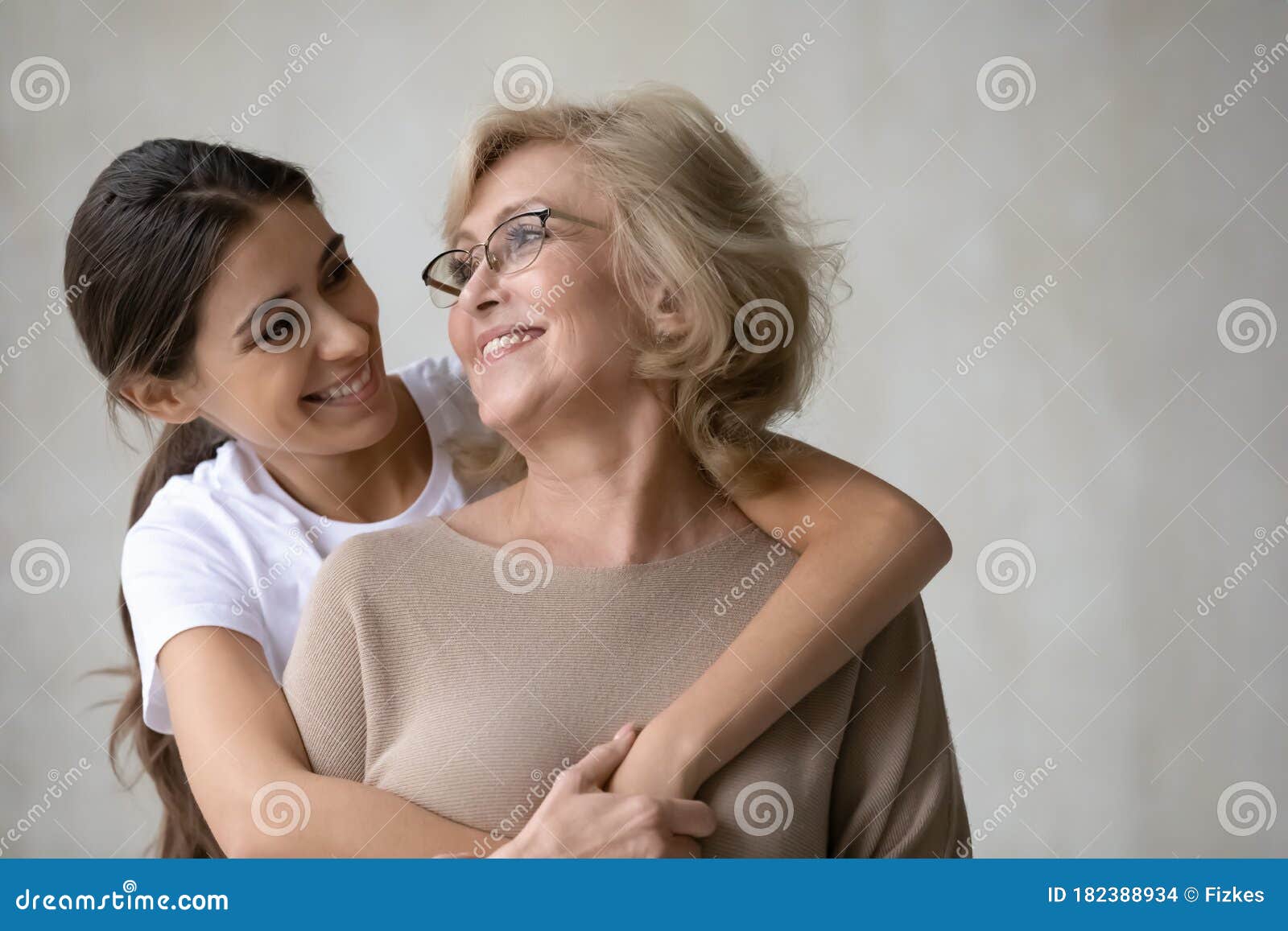 Adult Daughter Hugs from Behind Happy Mature Mother