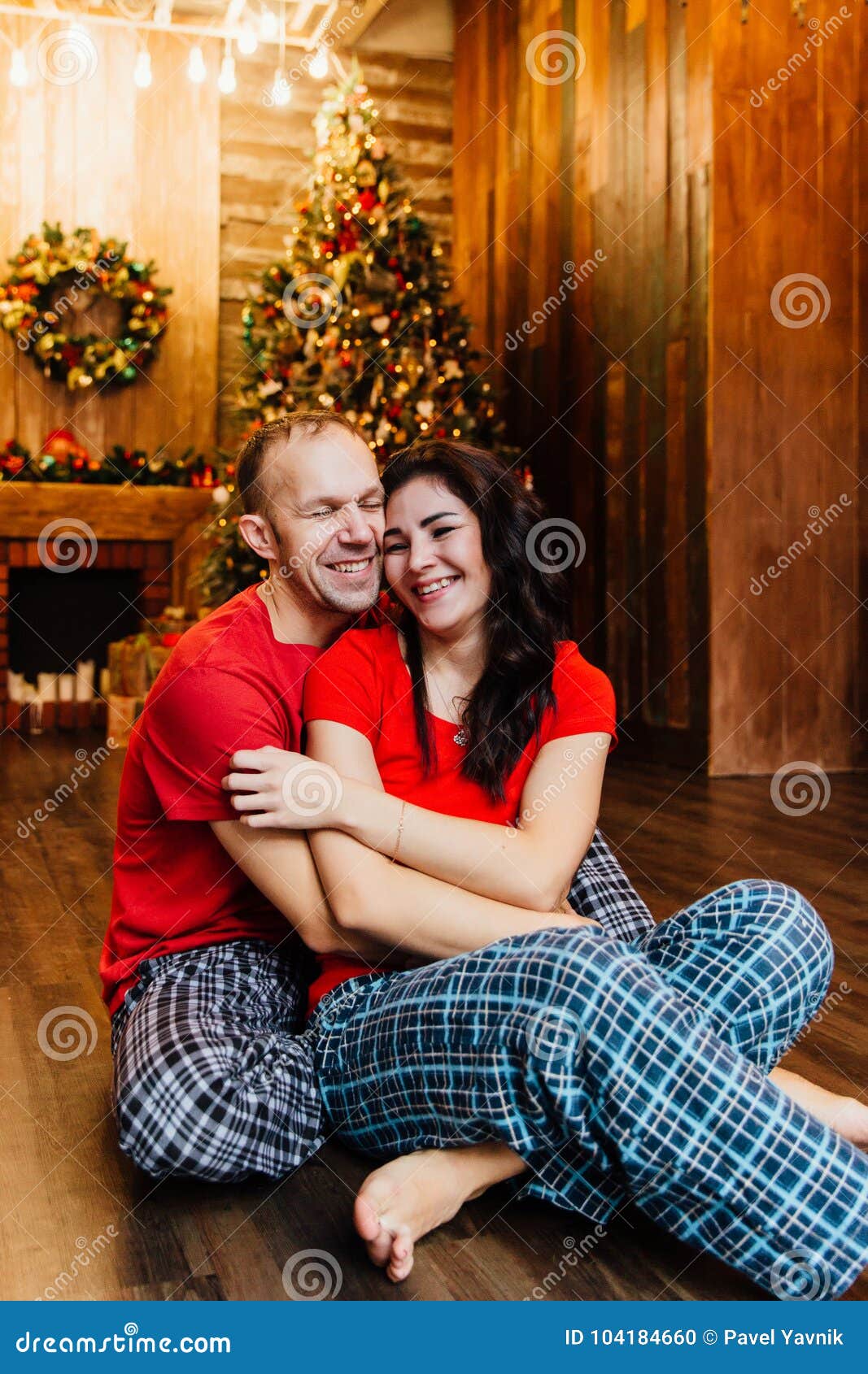 Adult Married Couple in Red T-shirts and Pajamas Embraces Sitting on ...