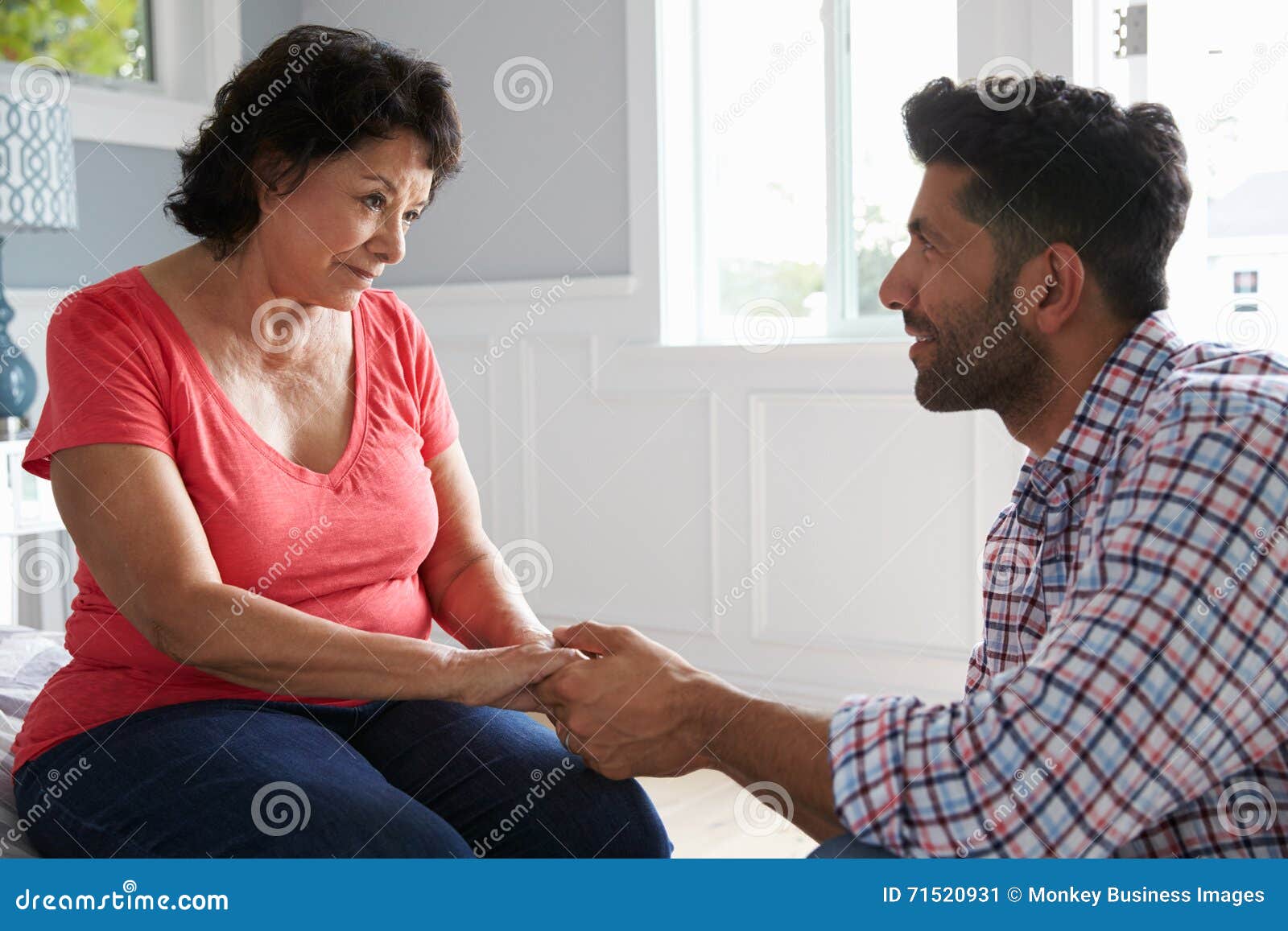 adult son comforting mother suffering with dementia