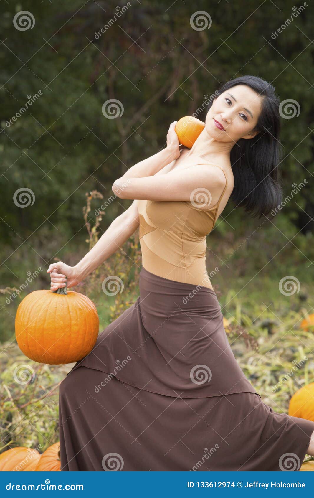 adult woman dancing in a connecticut pumpkin patch in autumn