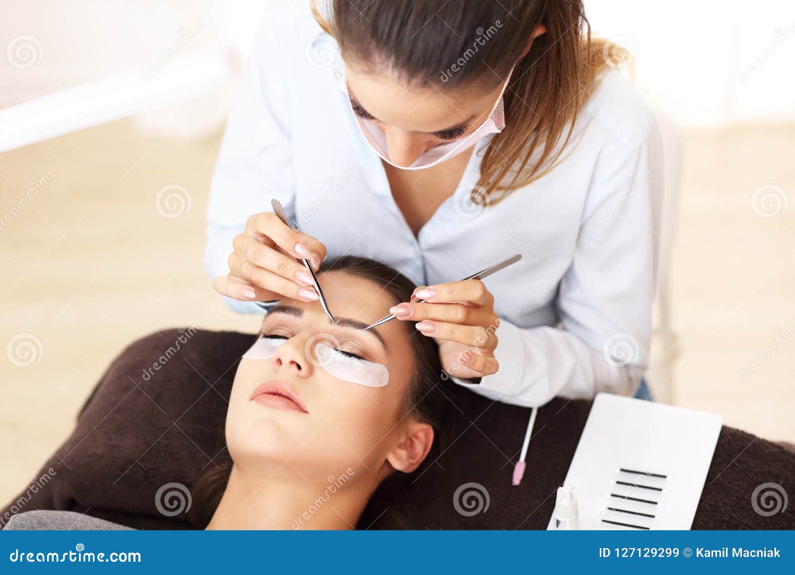 adult woman having eyelash extension in professional beauty salon