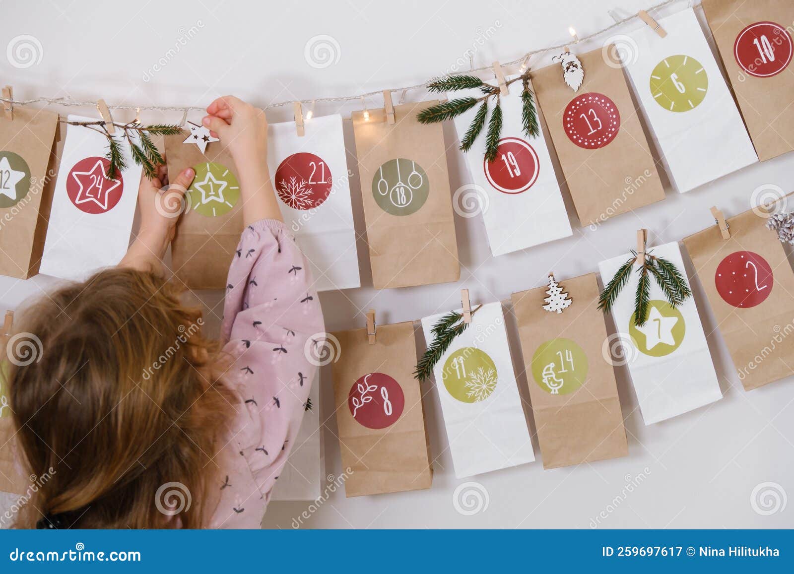 Advent Calendar Hanging on the Wall. Child Opens Christmas Present Bag
