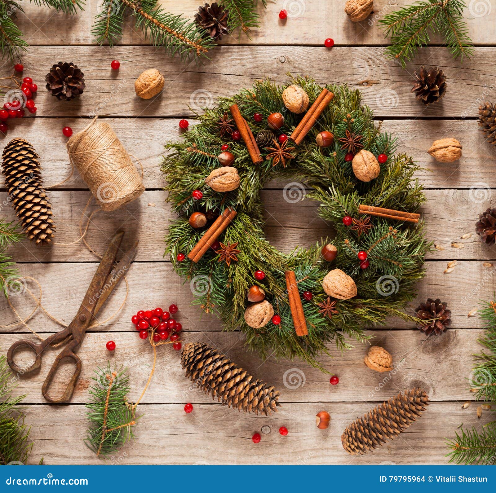advent christmas wreath decoration with natural decorations, pine cones spruce, nuts, candied fruit on wooden background