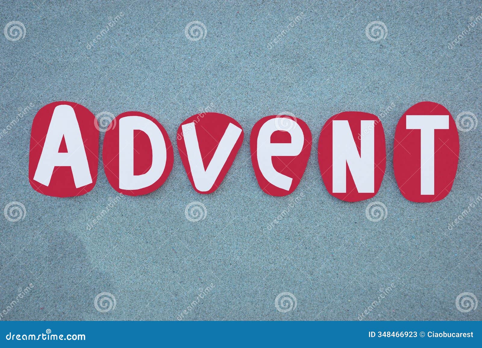 advent word, creative text composed with red colored hand painted stone letters over green sand
