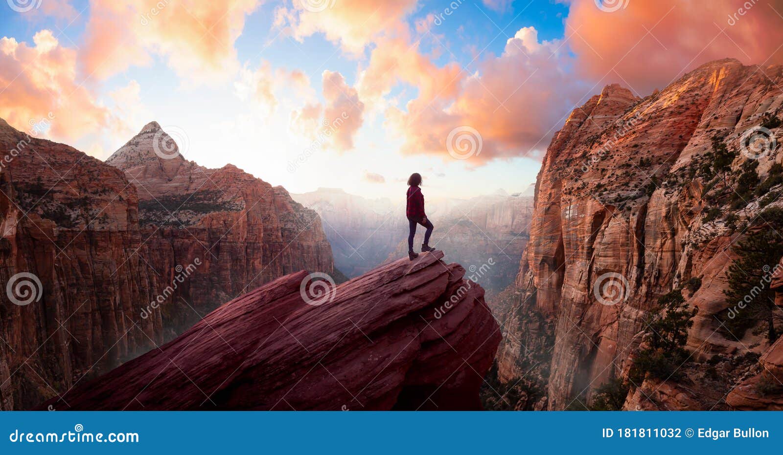 adventurous woman at the edge of a cliff is looking at a beautiful landscape view in the canyon