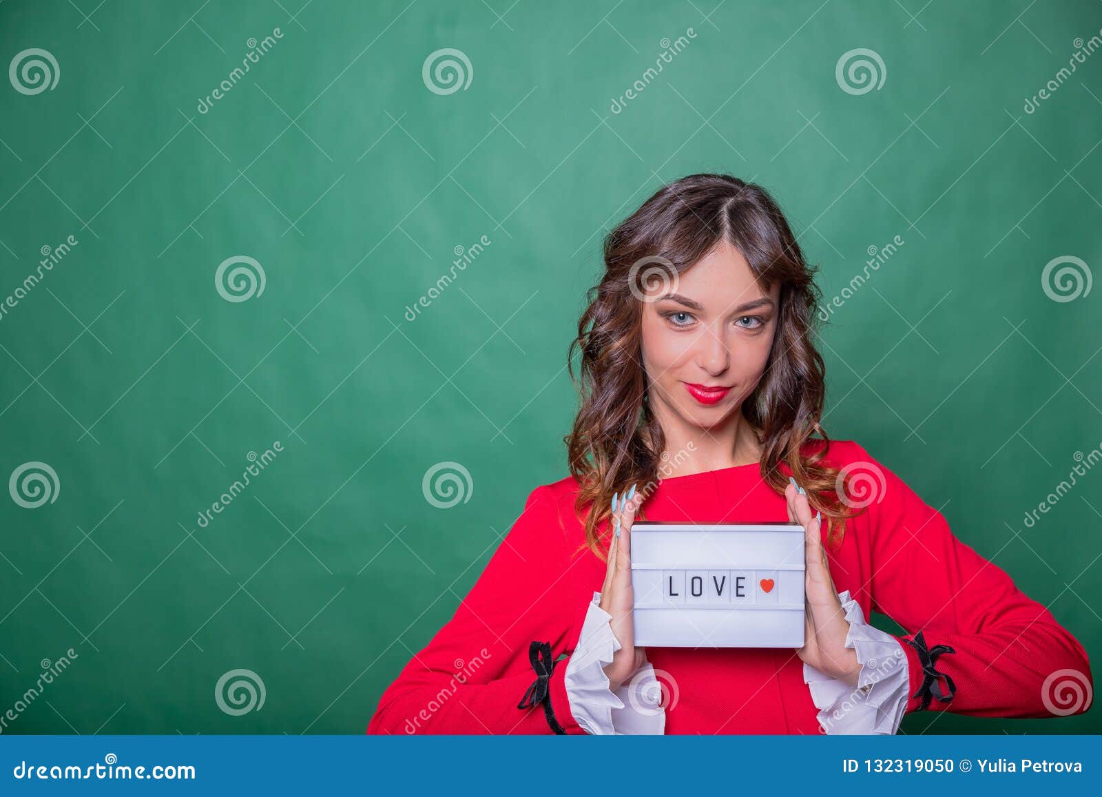 Advertising Femme dans la robe rouge Carte de sourire de conseil d'apparence de femme avec amour de mot et coeur rouge sur le fon. Advertising Femme dans la robe noire Femme de sourire montrant la carte vierge ou le papier sur le fond blanc