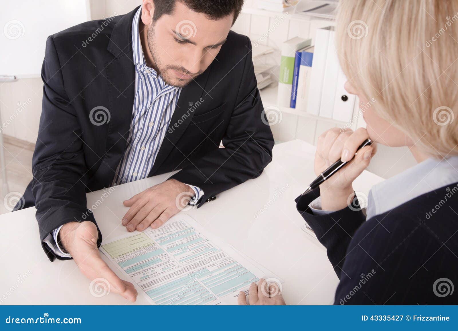 adviser sitting in a meeting with a blank on the table explaining something.