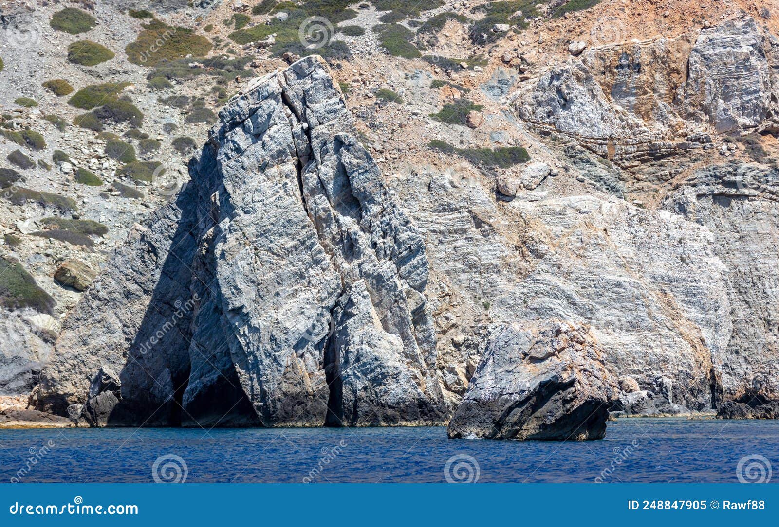 aegean sea. rocky coast, cliff and cave, rippled ocean. cyclades greece. seascape near nios island