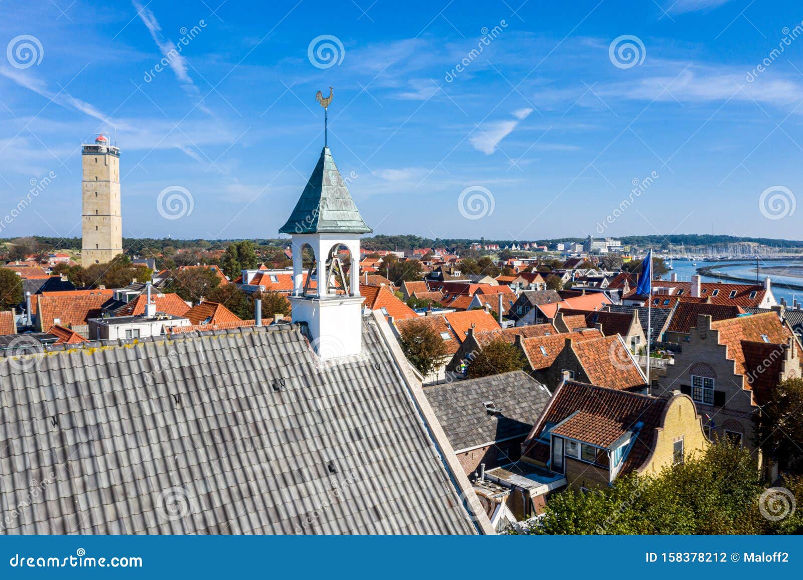 aerial close up of westerkerk church bell tower with rooster weather vane in west-terschelling, netherlands. brandaris lighthouse.