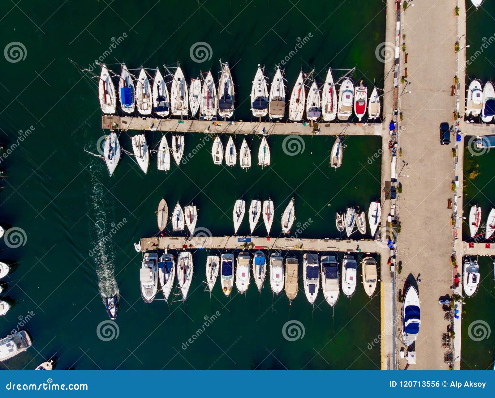 aerial drone view of marina with sailboats and motor boats docked in pier.