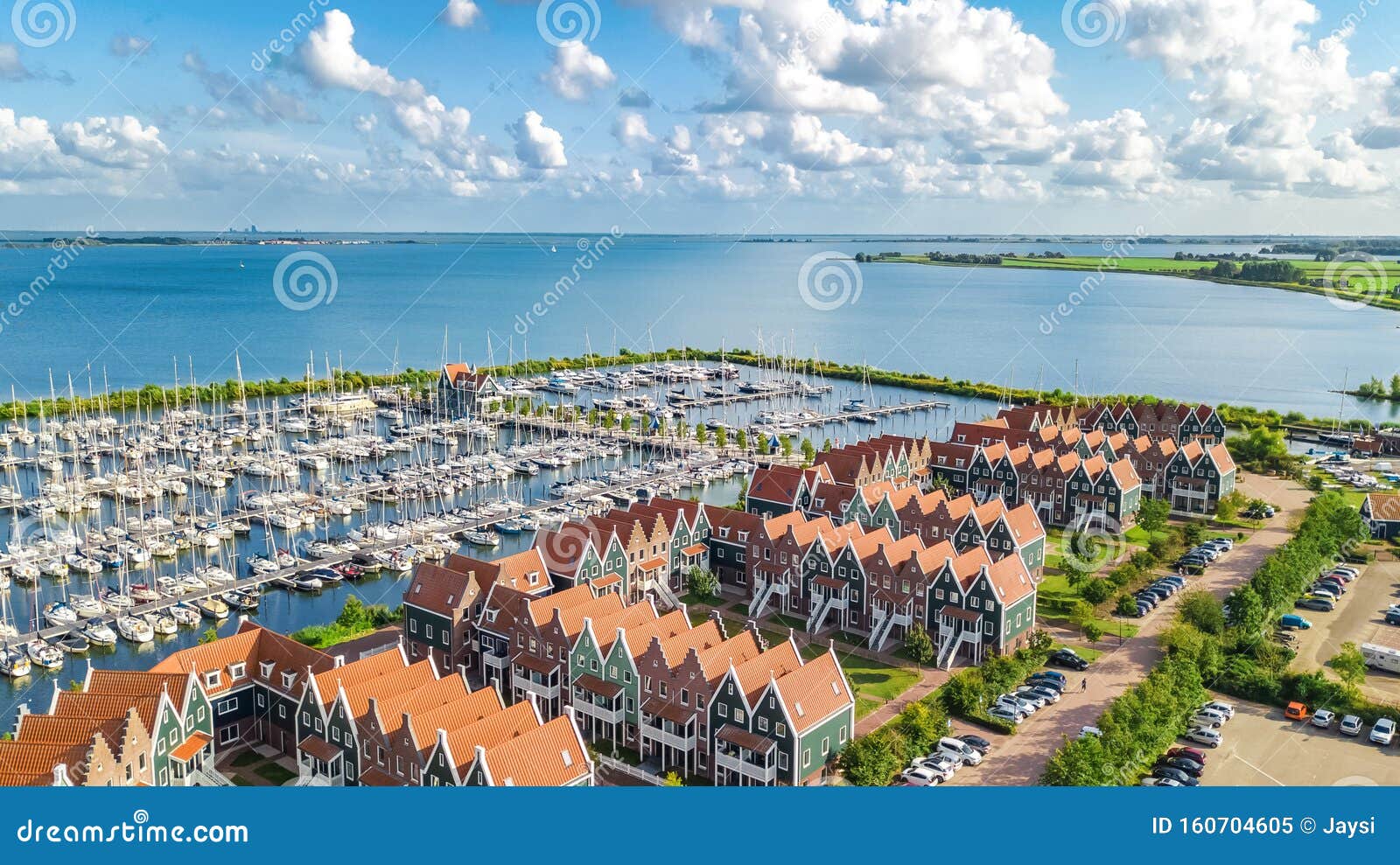 aerial drone view of typical modern dutch houses and marina in harbor, architecture of port of volendam town, holland, netherlands