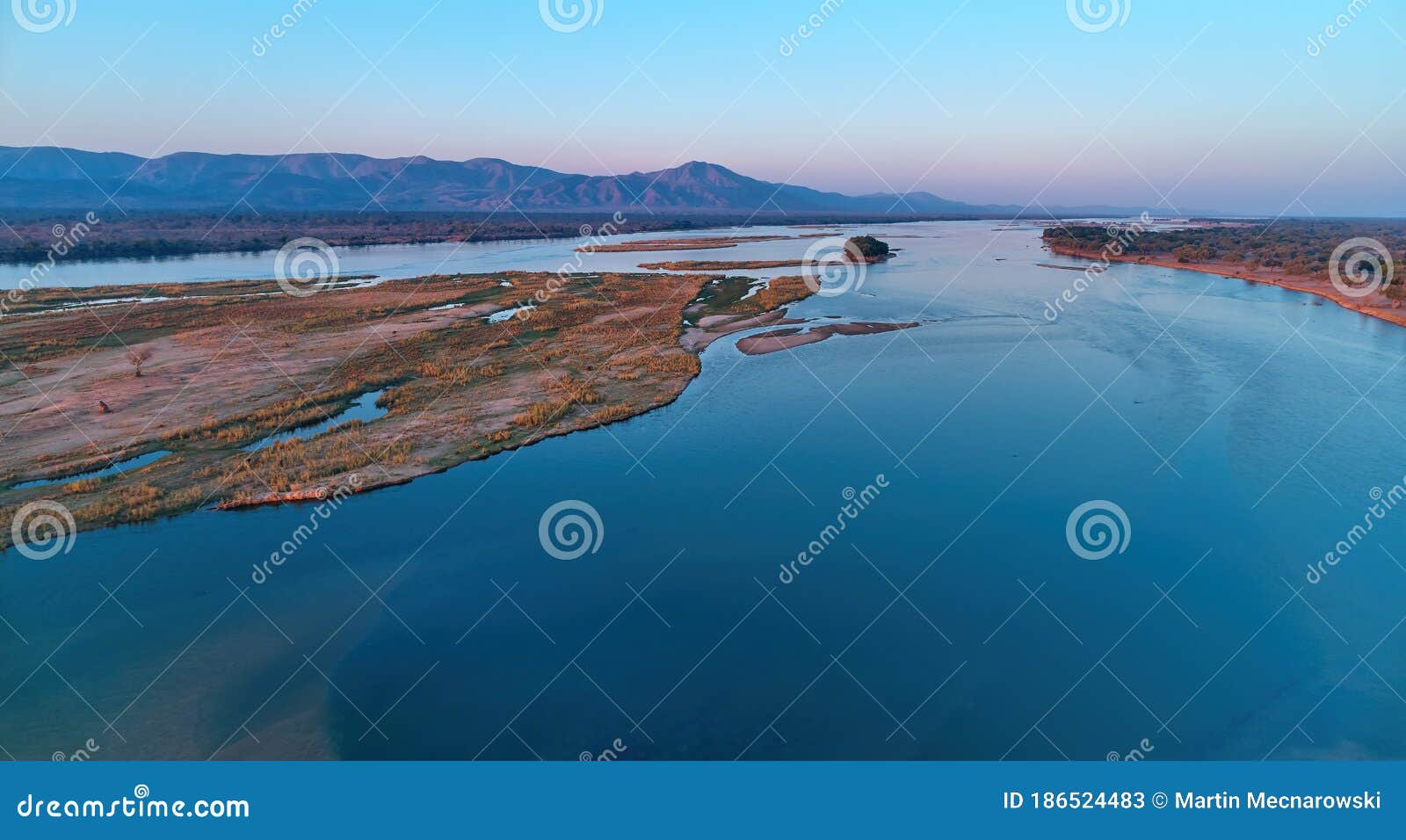 aerial, east view of zambezi river during sunset. view on african wilderness, mountains and huge river zambezi from above. border