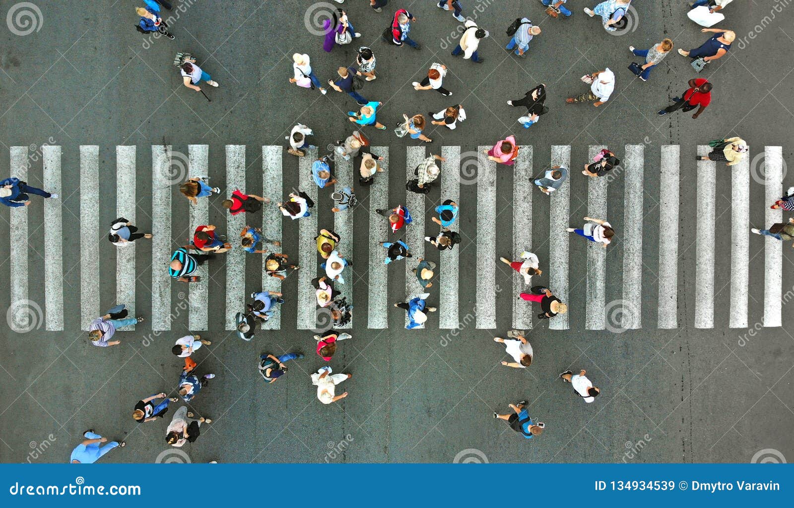 aerial. pedestrians passing a crosswalk. rush hour in the city. people are rushing to work.